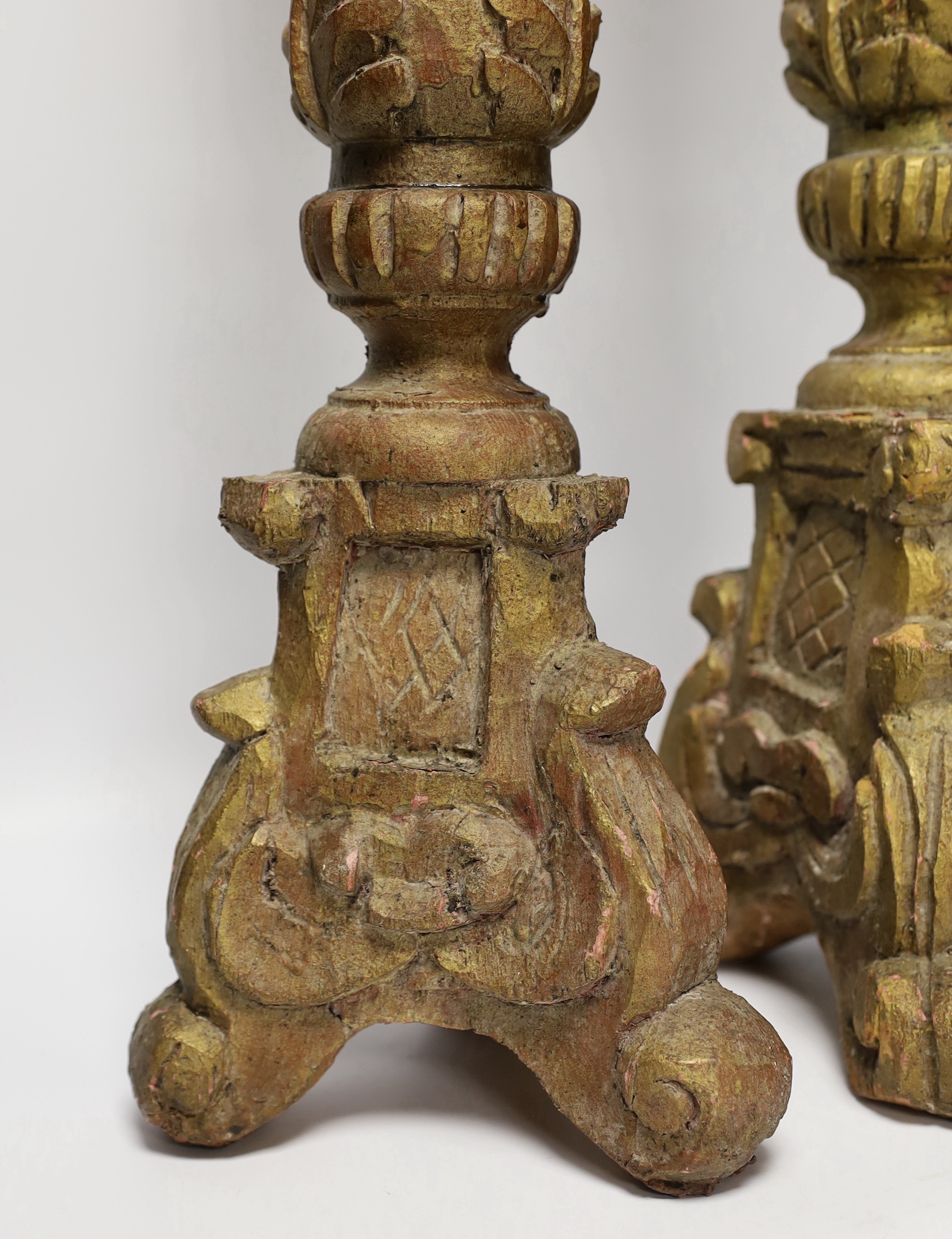 A pair of gilt and carved wooden altar sticks, 71cm